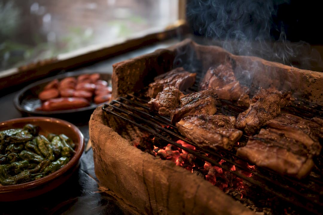 Parrilla con churrasco gallego chisporroteando y pimientos
