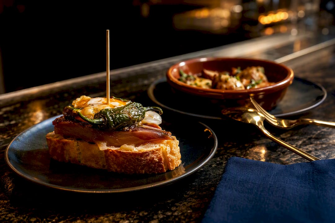 Pintxo y tapa frente a frente en la barra