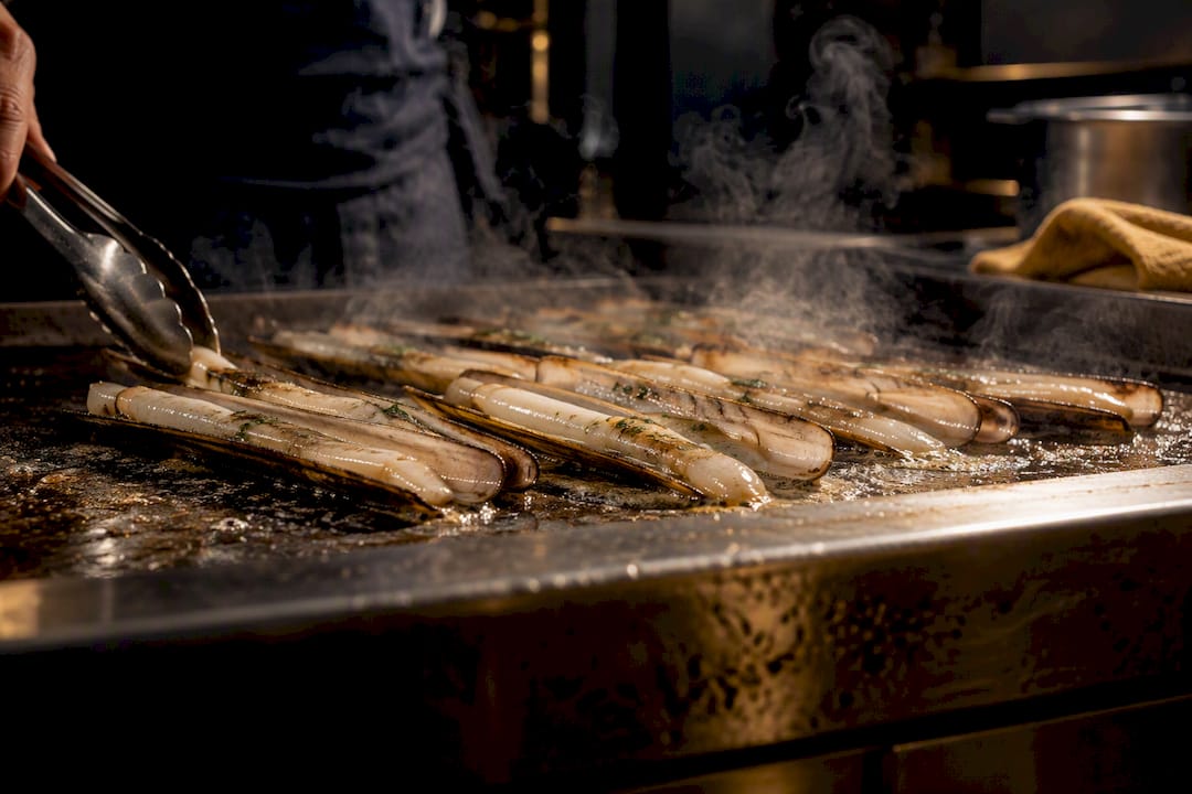 Navajas frescas cocinándose a la plancha caliente